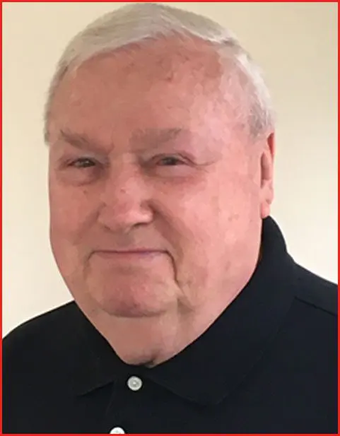 A man with white hair and wearing a black shirt.